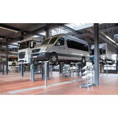 Useita ajoneuvoja, kuten pakettiauto ja kuorma-auto, nostettuna Blitzrotary Duplex Teleskooppisylinterinostinilla työpajassa.